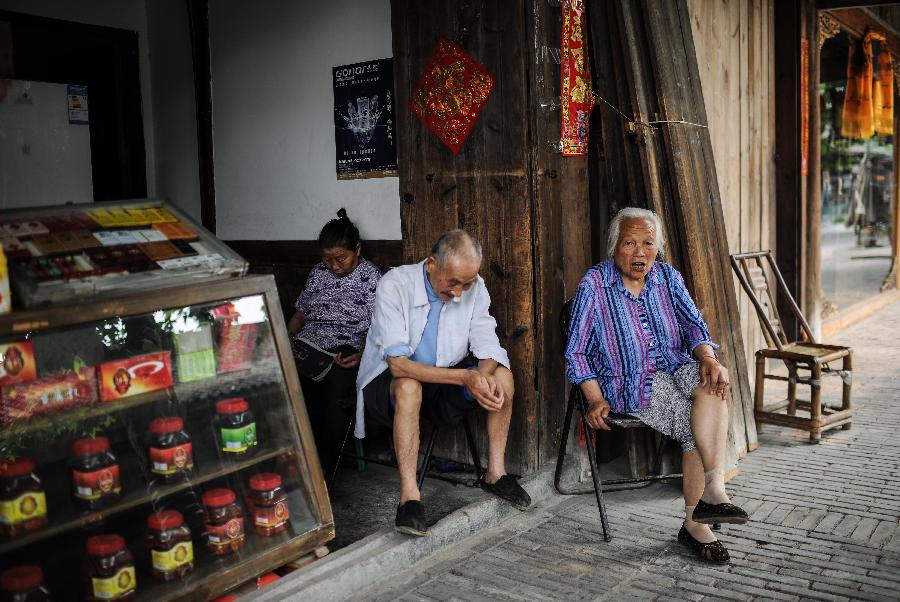 Senior residents chat at leisure at a shop in Anren, an ancient town in Dayi County of Chengdu, capital of southwest China's Sichuan Province, May 23, 2013. Anren Town was first built in ancient China's Tang Dynasty (618-907). Most of its buildings were constructed in late Qing Dynasty (1644-1911) and early Republic of China (1911-1949). Chengdu will host the Global Fortune Forum, an event to be organized by the American magazine "Fortune", on June 6-8. (Xinhua/Shen Hong) 