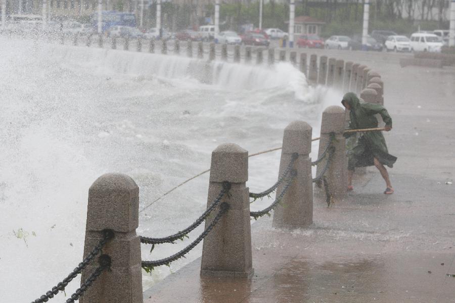 A fisherman catches floats against the storm by a seaside in Yantai City, east China's Shandong Province, May 27, 2013. Shandong will witness frequent thunderstorms and downpours from Monday to Tuesday, according to the local meteorological authority. (Xinhua/Shen Jizhong)