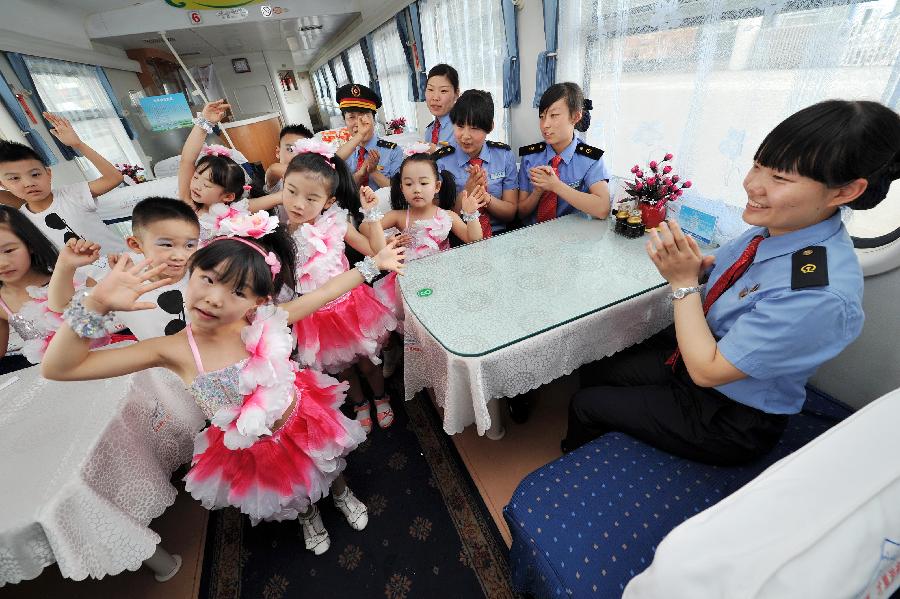 Children perform on a train from Yinchuan, capital of northwest China's Ningxia Hui Autonomous Region, to Beijing, capital of China, May 27, 2013. Children from the kindergarten of Ningxia University visited the train and held a performance to celebrate the upcoming Children's Day. (Xinhua/Peng Zhaozhi)