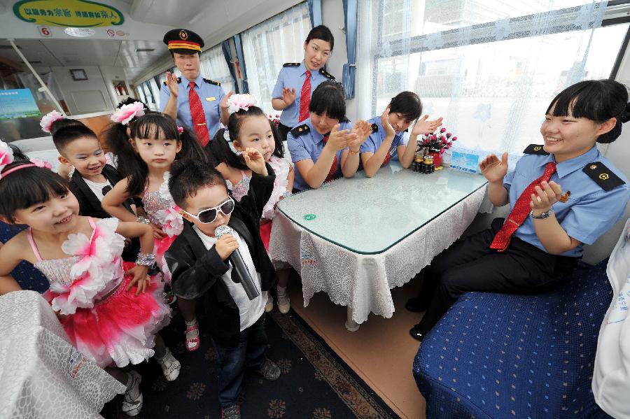  Children perform on a train from Yinchuan, capital of northwest China's Ningxia Hui Autonomous Region, to Beijing, capital of China, May 27, 2013. Children from the kindergarten of Ningxia University visited the train and held a performance to celebrate the upcoming Children's Day. (Xinhua/Peng Zhaozhi)