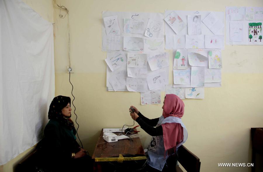 An Afghan woman poses for a picture to receive voter card at a voter registration center in Kabul, Afghanistan on May 27, 2013. The voter registration process for the general elections scheduled for April 5, 2014 started in Afghanistan on May 26, the country's election commission said in a press release.(Xinhua/Ahmad Massoud)  