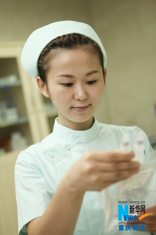 Wang Lingling checks the infusion devices in Chongqiing South West Hospital. (Xinhua/Peng Bo)