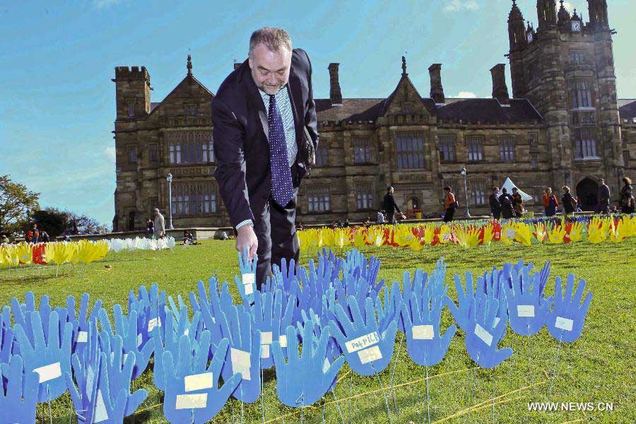 A man plants a plastic hand in the large art work of "The Sea of Hands" during the Reconciliation Week 2013 in the University of Sydney, Australia, on May 27, 2013. The first "Sea of Hands" was held on Oct. 12, 1997, in Australia's capital Canberra. (Xinhua/Jin Linpeng) 