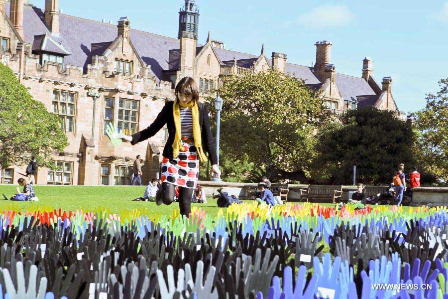 A girl student plants a plastic hand in the large art work of "The Sea of Hands" during the Reconciliation Week 2013 in the University of Sydney, Australia, May 27, 2013. The first "Sea of Hands" was held on Oct. 12, 1997, in Australia's capital of Canberra. (Xinhua/Jin Linpeng) 