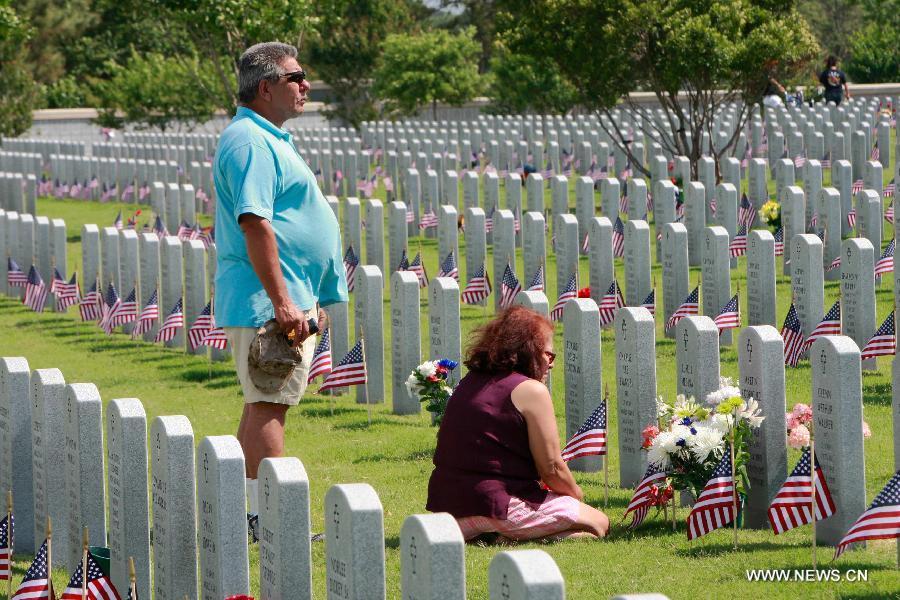 Rodriguez mourns for his father with his wife on the Memorial Day at the Houston National Cemetery in Houston, the United States, May 27, 2013. (Xinhua/Song Qiong) 