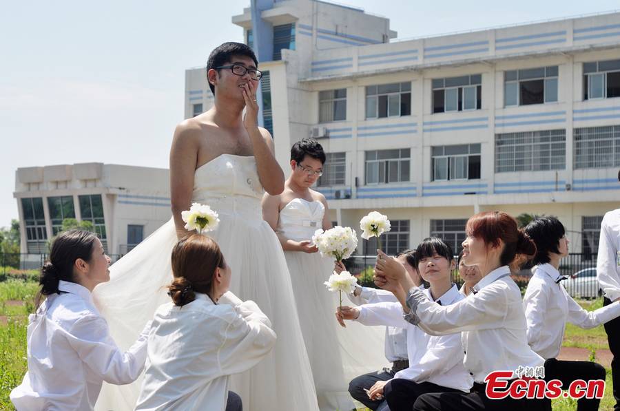 Boys wearing wedding dresses and girls in men's suits pose for graduation group photos at Hunan University of Arts and Science in Changde, central China's Hunan Province. (CNS /Jia Siyuan)