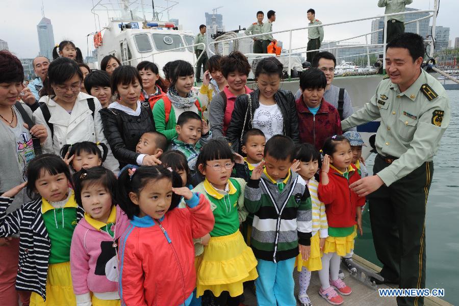 Children visit a patrol boat dock during an open day of local frontier defense vessel division in Qingdao, a coastal city in east China's Shandong Province, May 28, 2013. (Xinhua/Li Ziheng)