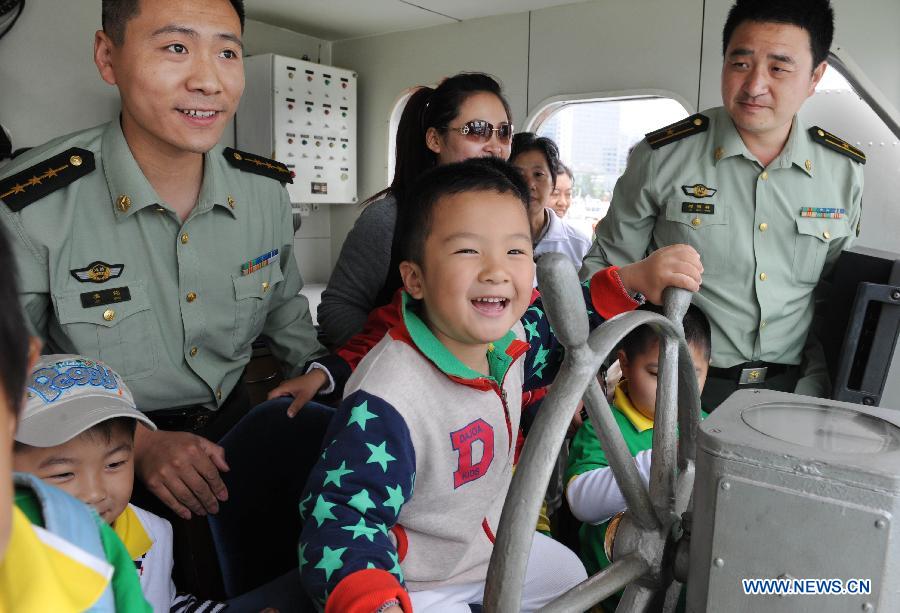 Children visit a patrol boat during an open day of local frontier defense vessel division in Qingdao, a coastal city in east China's Shandong Province, May 28, 2013. (Xinhua/Li Ziheng)