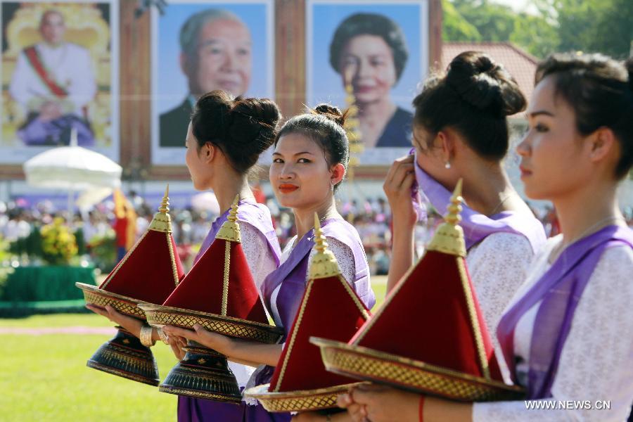 Women hold plates of food for royal oxen during the ancient royal plowing ceremony in eastern Kampong Cham province of Cambodia, May 28, 2013. Cambodia on Tuesday observed the ancient royal plowing ceremony, a ritual to mark the annual start of agricultural season in this Southeast Asian nation, where about 80 percent of the population are farmers. (Xinhua/Sovannara) 