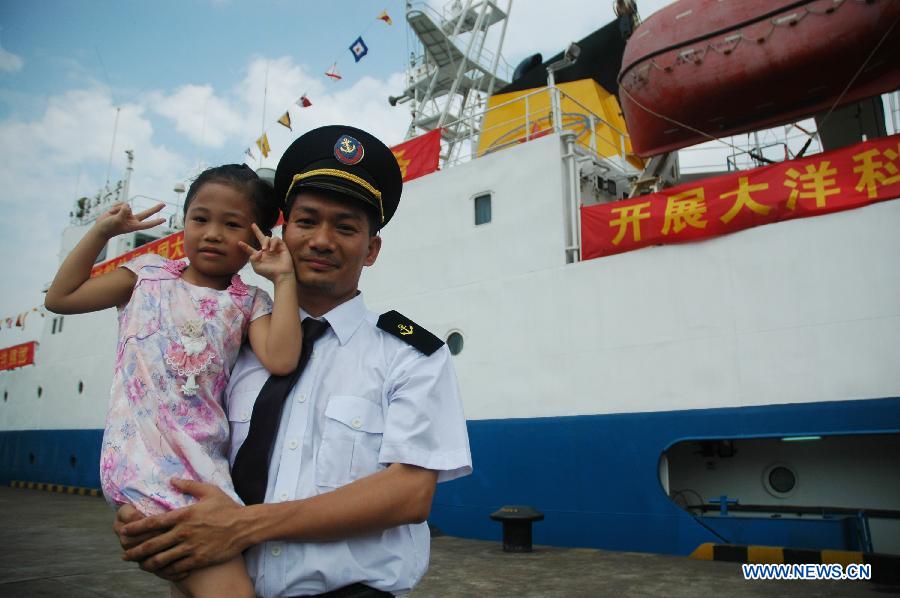 A member of an expedition team poses for a photo with his daughter beside Haiyang-6, a Chinese research vessel, at a dock in Guangzhou, capital of south China's Guangdong Province, May 28, 2013. An expedition team of 96 members aboard Haiyang-6 set out for the Pacific Ocean Tuesday to carry out a five-month survey on undersea mineral resources. (Xinhua/Liang Zhiwei) 