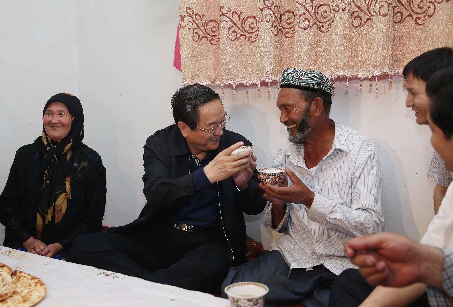Photo taken on May 23, 2013 shows Yu Zhengsheng (2nd L), a member of the Standing Committee of the Political Bureau of the Communist Party of China (CPC) Central Committee and chairman of the National Committee of the Chinese People's Political Consultative Conference, visits villagers of the Uygur ethnic group at Yurungkax Town in Hotan City, northwest China's Xinjiang Uygur Autonomous Region. Yu paid an inspection tour in Hotan, Kashgar, Yili and Urumqi of Xinjiang from May 23 to 28. (Xinhua/Liu Weibing)