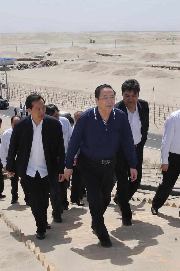 Photo taken on May 23, 2013 shows Yu Zhengsheng (front), a member of the Standing Committee of the Political Bureau of the Communist Party of China (CPC) Central Committee and chairman of the National Committee of the Chinese People's Political Consultative Conference, checks desertification presention and control in Hotan County, northwest China's Xinjiang Uygur Autonomous Region. Yu paid an inspection tour in Hotan, Kashgar, Yili and Urumqi of Xinjiang from May 23 to 28. (Xinhua/Liu Weibing)