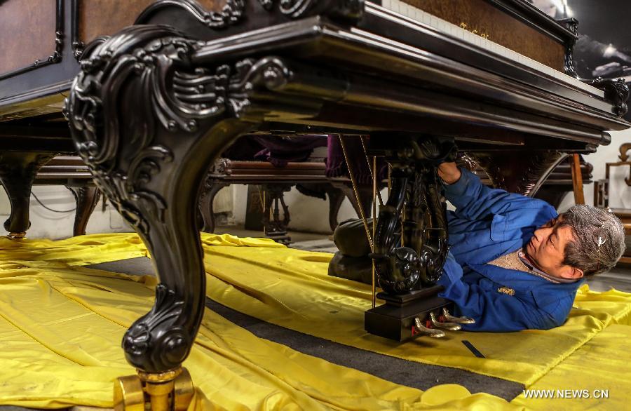 Photo taken on May 8, 2013 shows Zhang Gangning, a piano maker, installs parts into a piano in Nanjing, capital of east China's Jiangsu Province.  (Xinhua/Yang Lei)