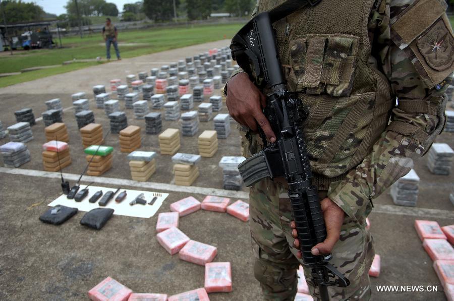 A member of the Aeronaval National Service guards cocaine packs siezed in the "Santisima Trinidad" operation, in the Guna Yala shire, during a presentation to media, in Panama City, capital of Panama, on May 27, 2013. According to official sources, the 2,717 kilograms of cocaine and two kilograms of marijuana are the biggest drug seizure by now in 2013, accomplished with United States support. The Aeronaval National Service has seized over 10,000 kilograms of illegal substances so far this year. (Xinhua/Mauricio Valenzuela) 