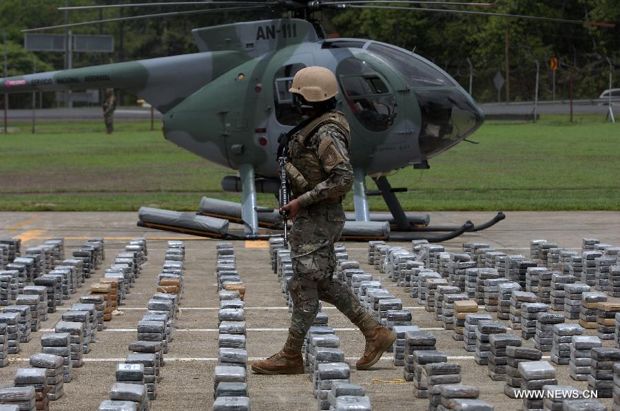 A member of the Aeronaval National Service guards cocaine packs siezed in the "Santisima Trinidad" operation, in the Guna Yala shire, during a presentation to media, in Panama City, capital of Panama, on May 27, 2013. According to official sources, the 2,717 kilograms of cocaine and two kilograms of marijuana are the biggest drug seizure by now in 2013, accomplished with United States support. The Aeronaval National Service has seized over 10,000 kilograms of illegal substances so far this year. (Xinhua/Mauricio Valenzuela) 