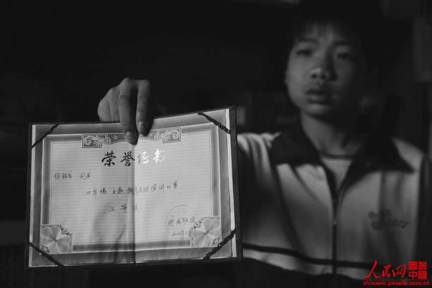 Shenglong shows his awards at school.