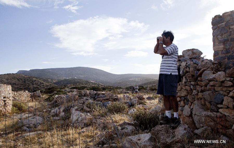 Yiannis Gavalas, a principal of the only school in Iraklia island, explores on a hill in Iraklia island, Greece, on May 23, 2013. For over 20 years, Gavalas has been working in this tiny island covers an area of 18 square kilometers with more than 100 residents. He has recorded about 650 species of plants, 174 species of birds and 26 species of butterflies in his spare time. He has published a book about local butterflies and more will follow. (Xinhua/Liu Yongqiu)