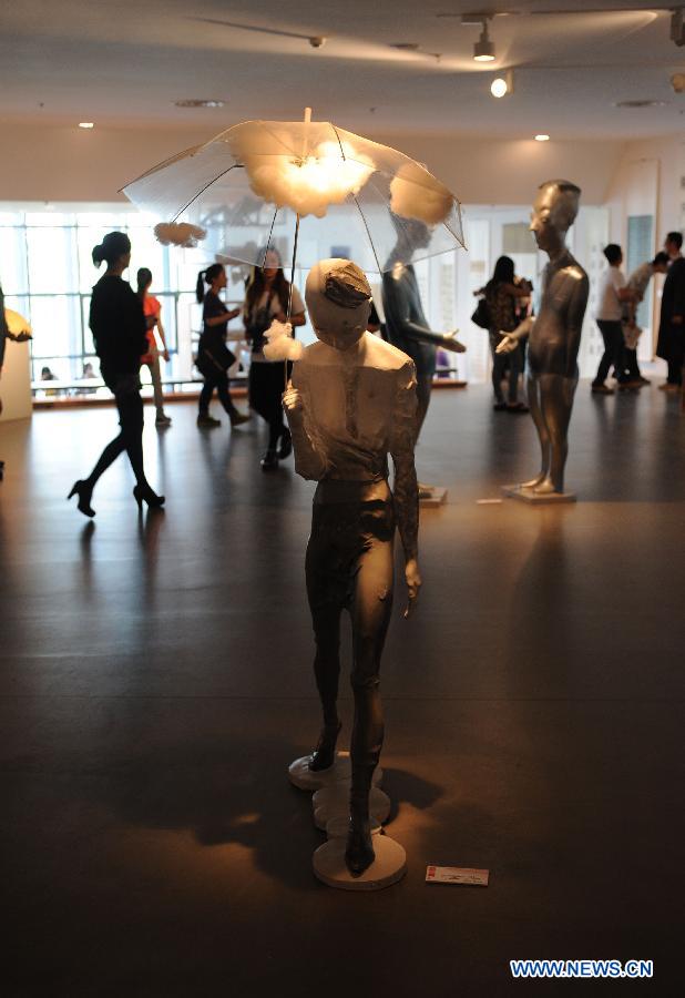 Visitors watch the sculpture works created by graduates from Nanjing University of the Arts in Nanjing, capital of east China's Jiangsu Province, May 28, 2013. (Xinhua/Sun Can)  