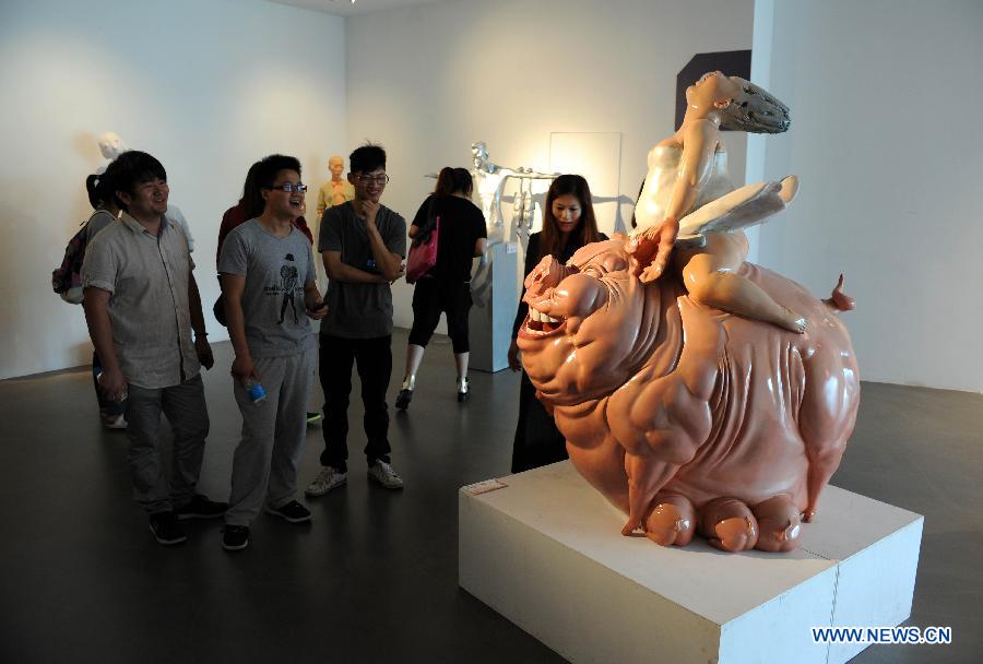 Visitors watch the sculpture works created by graduates from Nanjing University of the Arts in Nanjing, capital of east China's Jiangsu Province, May 28, 2013. (Xinhua/Sun Can) 