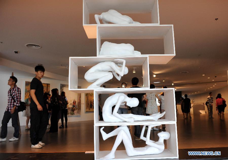 Visitors watch the sculpture and painting works created by graduates from Nanjing University of the Arts in Nanjing, capital of east China's Jiangsu Province, May 28, 2013. (Xinhua/Sun Can)  