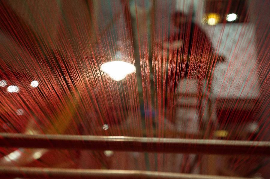 A weaver weaves Shu brocade, a traditional artwork in southwest China's Sichuan Province, with a loom, in Chengdu, capital of Sichuan, May 27, 2013. Imparted from generation to generation for over 2,000 years, Shu brocade weaving techniques have been put on China's Intangible Cultural Heritage List in 2006. (Xinhua/Li Qiaoqiao) 