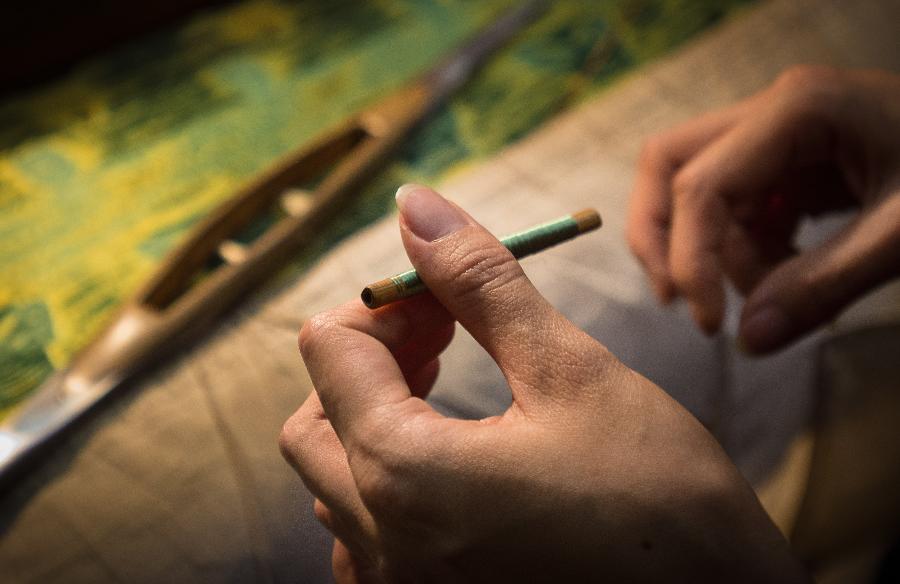 A weaver weaves Shu brocade, a traditional artwork in southwest China's Sichuan Province, with a loom, in Chengdu, capital of Sichuan, May 27, 2013. Imparted from generation to generation for over 2,000 years, Shu brocade weaving techniques have been put on China's Intangible Cultural Heritage List in 2006. (Xinhua/Li Qiaoqiao) 