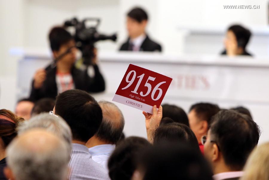A buyer competes during an auction of the Asian 20th Century & Contemporary Art held by Christie's in Hong Kong, south China, May 28, 2013. The five-day Christie's 2013 Spring auctions kicked off in Hong Kong on May 25 this year. (Xinhua/Li Peng)