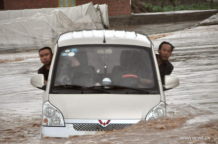 A vehicle is trapped in the rain-triggered flood in Changba Village of Bijie City, southwest China's Guizhou Province, May 29, 2013. Heavy rainfall hit the city from Tuesday to Wednesday. (Xinhua/Deng Jie) 