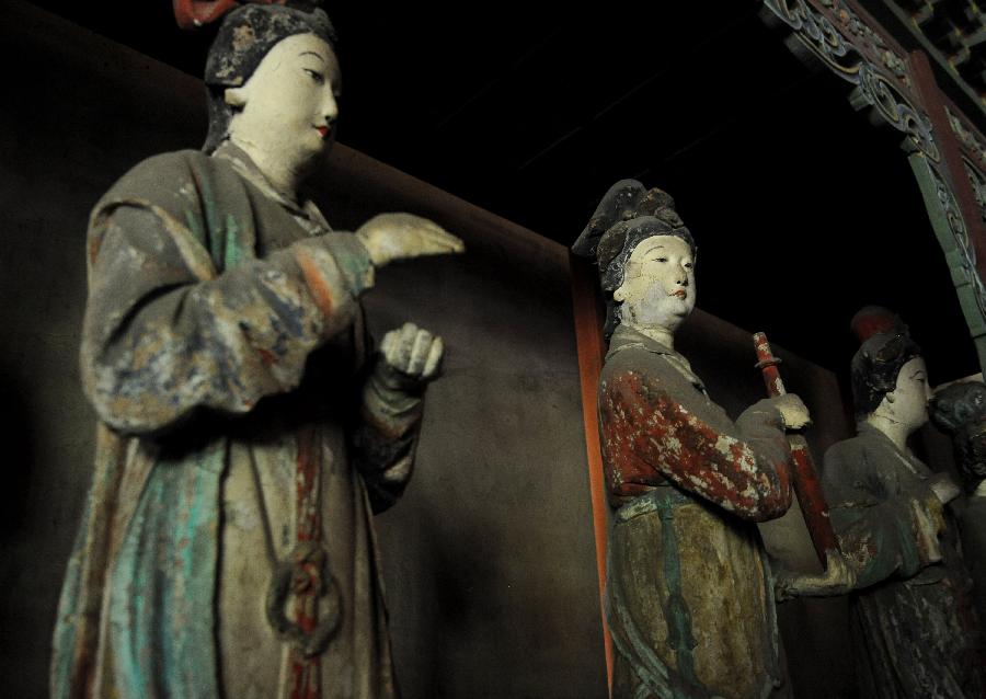 Photo taken on May 24, 2013 shows colored sculptures at the Shengmu Dian (Hall of the Saint Mother) of Jinci Temple in Taiyuan, capital of north China's Shanxi Province. Jinci Temple was first built during the period of the Northern Wei (386-534) in commemoration of Shuyu, the second son of Emperor Wuwang of the Zhou dynasty (1100-771 BC). Shengmu Dian is the principal hall in the temple, built to honor the mother of Shuyu, featuring 42 various sculptures of maids. (Xinhua/Yan Yan) 