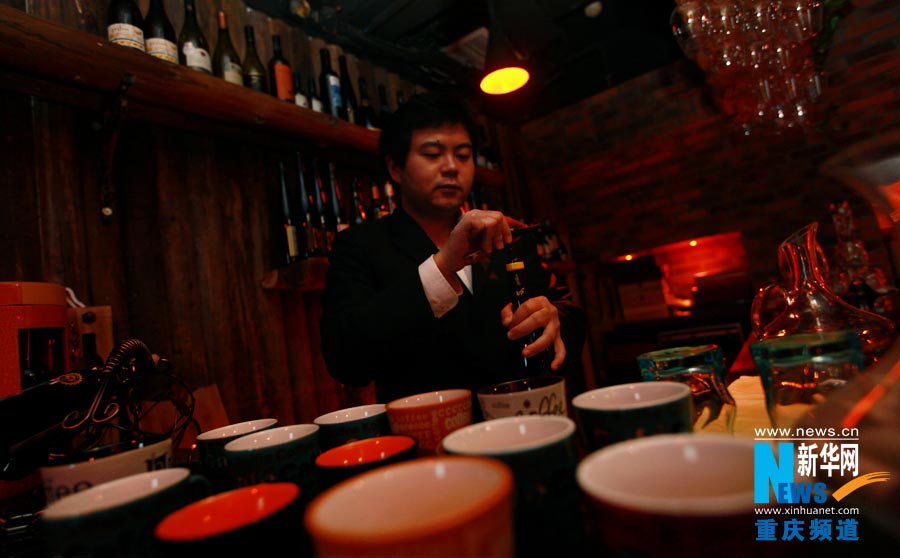 The owner of Zijue wine cellar serves to visitors. (Photo/ Xinhua)