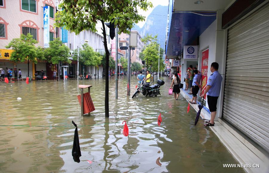 Policemen hold warning lines to prevent people from walking into deep water zones in Fengshan County, south China's Guangxi Zhuang Autonomous Region, May 29, 2013. Fengshan County was hit by the heaviest rainfall of the year on Wednesday morning. (Xinhua/Zhou Enge)