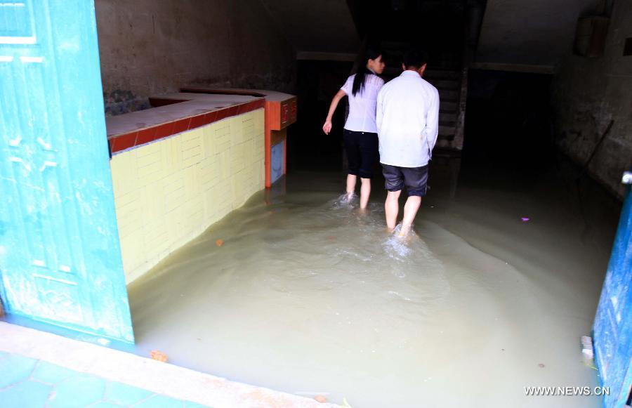 People walk in a flooded shop in Fengshan County, south China's Guangxi Zhuang Autonomous Region, May 29, 2013. Fengshan County was hit by the heaviest rainfall of the year on Wednesday morning. (Xinhua/Zhou Enge)