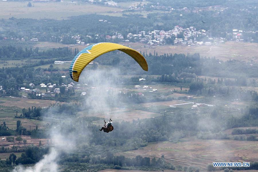 A paraglider glides over the agricultural fields on the outskirts of Srinagar city, the summer capital of Indian-controlled Kashmir, May 29, 2013. The tourism department in Indian-controlled Kashmir organised a two-day paragliding event to boost tourism at the restive region. (Xinhua/Javed Dar)
