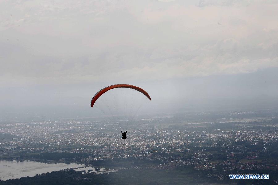A paraglider glides over the Dal lake in Srinagar city, the summer capital of Indian-controlled Kashmir, May 29, 2013. The tourism department in Indian-controlled Kashmir organised a two-day paragliding event to boost tourism at the restive region. (Xinhua/Javed Dar)