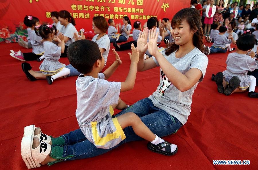 Children dance with their parents at the Dongfang Kindergarten in a celebration for the forthcoming International Children's Day in Yuncheng City, north China's Shanxi Province, May 29, 2013. (Xinhua/Xue Jun)