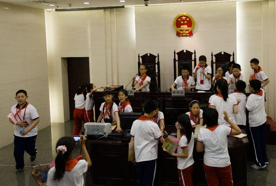 Students from Banchang Elementary School visit a courtroom at the Supreme People's Court on the court's open day in Beijing, capital of China, May 30, 2013. More than 120 students and teachers from Banchang Elementary School and No. 166 Middle School visited the Supreme People's Court on its open day on May 30. (Xinhua/Wang Quanchao)