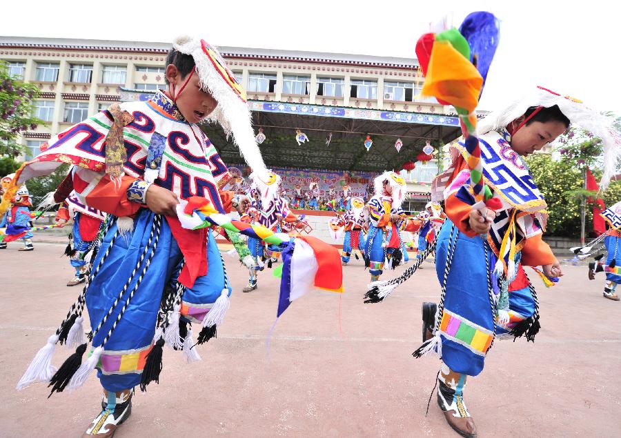 Students perform mask dance to celebrate the coming International Children's Day in Lhasa, capital of southwest China's Tibet Autonomous Region, May 30, 2013. Various activities are held in Chinese cities to celebrate the coming International Children's Day. (Xinhua/Liu Kun) 