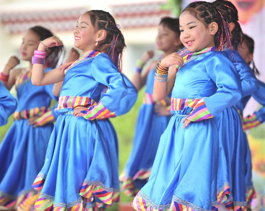 Students perform dance to celebrate the coming International Children's Day in Lhasa, capital of southwest China's Tibet Autonomous Region, May 30, 2013. Various activities are held across China to celebrate the coming International Children's Day. (Xinhua/Liu Kun) 