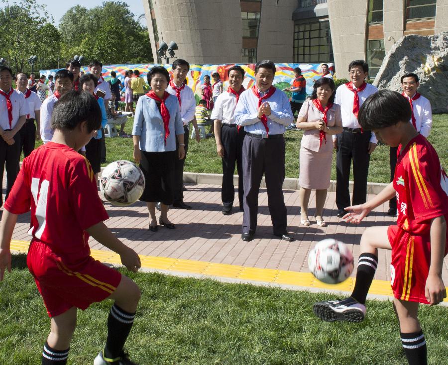 Chinese President Xi Jinping watches children playing football during a children's activity in Beijing, capital of China, May 29, 2013. (Xinhua/Li Xueren)  