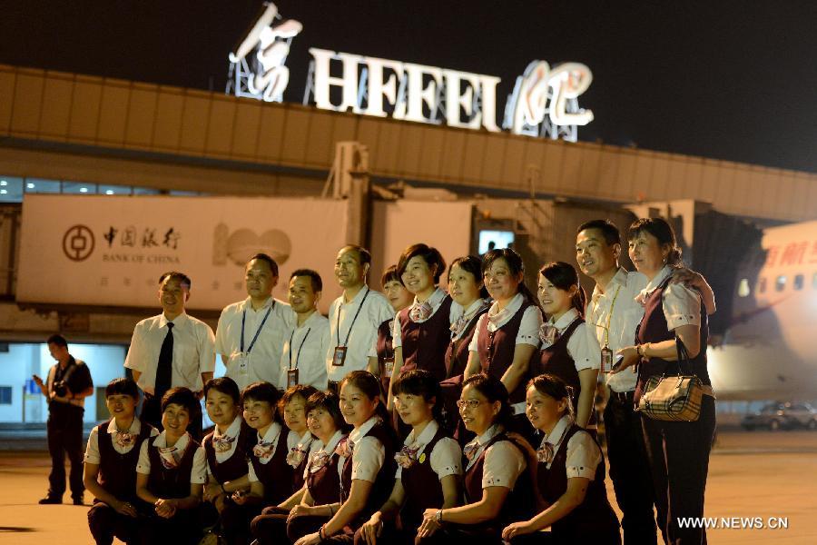 Working staff pose for group photo at the landing field of the Hefei Luogang International Airport in east China's Anhui Province, May 29, 2013. Located in Gaoliu Town of Feixi County, 31.8 kilometers away from the center of Hefei City, Hefei Xinqiao International Airport has replaced Luogang International Airport as Hefei's main airport. (Xinhua/Zhang Duan)