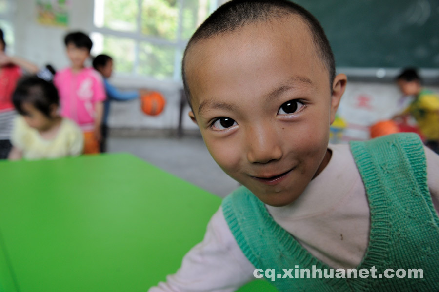 A preschool student poses for a photo. (Photo by Huang Junhui/ cq.xinhuanet.com)