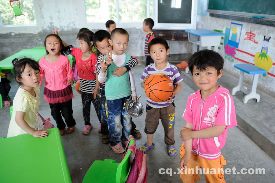 Preschool students pose for a photo. 90 percent of students in Shijiao Yingshan School are left-behind children separated from their parents who seek jobs in big cities. (Photo by Huang Junhui/ cq.xinhuanet.com)