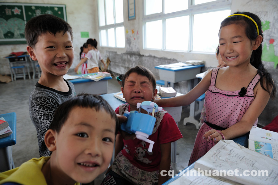 Students in grade three pose for a photo. The boy in the middle cried because his classmate broke his pencil sharper. (Photo by Huang Junhui/ cq.xinhuanet.com)