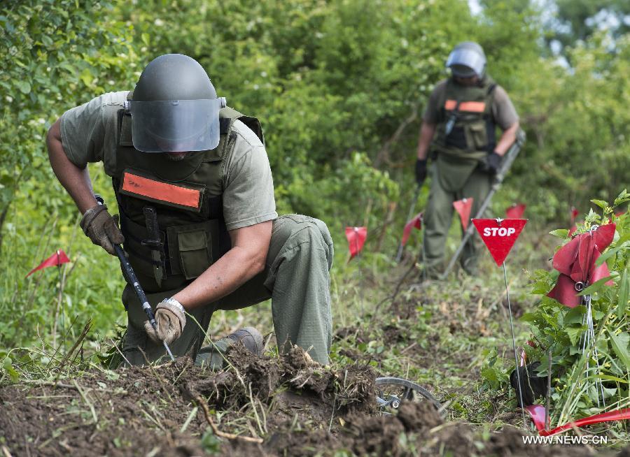 De-miners search for landmines near Lasinja, a village 40 kilometers south of Zagreb, capital of Croatia, May 29, 2013. Croatia is clearing 667 square kilometers of minefields in 12 counties, 93 cities and municipalities. These areas are thought to contain approximately 90,000 land mines left over since the Croatian War in early 1990s. (Xinhua/Miso Lisanin) 