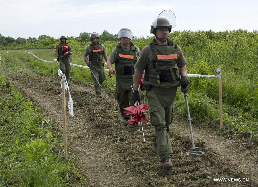 De-miners walk to a landmine field near Lasinja, a village 40 kilometers south of Zagreb, capital of Croatia, May 29, 2013. Croatia is clearing 667 square kilometers of minefields in 12 counties, 93 cities and municipalities. These areas are thought to contain approximately 90,000 land mines left over since the Croatian War in early 1990s. (Xinhua/Miso Lisanin) 