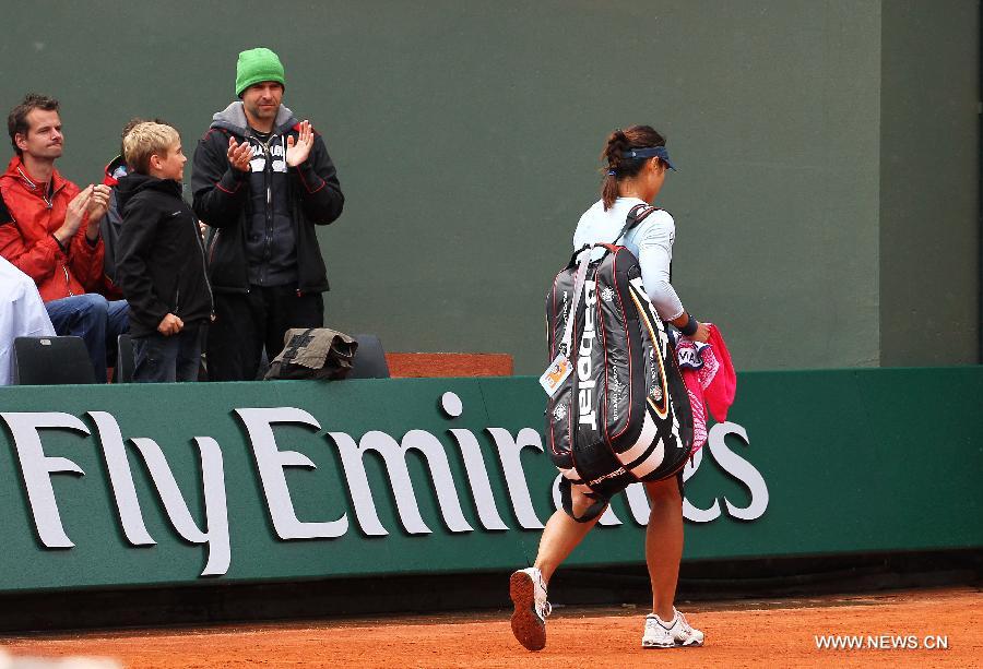 Li Na of China leaves the court after the women's singles second round match against Bethanie Mattek Sands of the United States at the French Open tennis tournament at the Roland Garros stadium in Paris, France, May 30, 2013. Li Na lost the match 1-2. (Xinhua/Gao Jing)