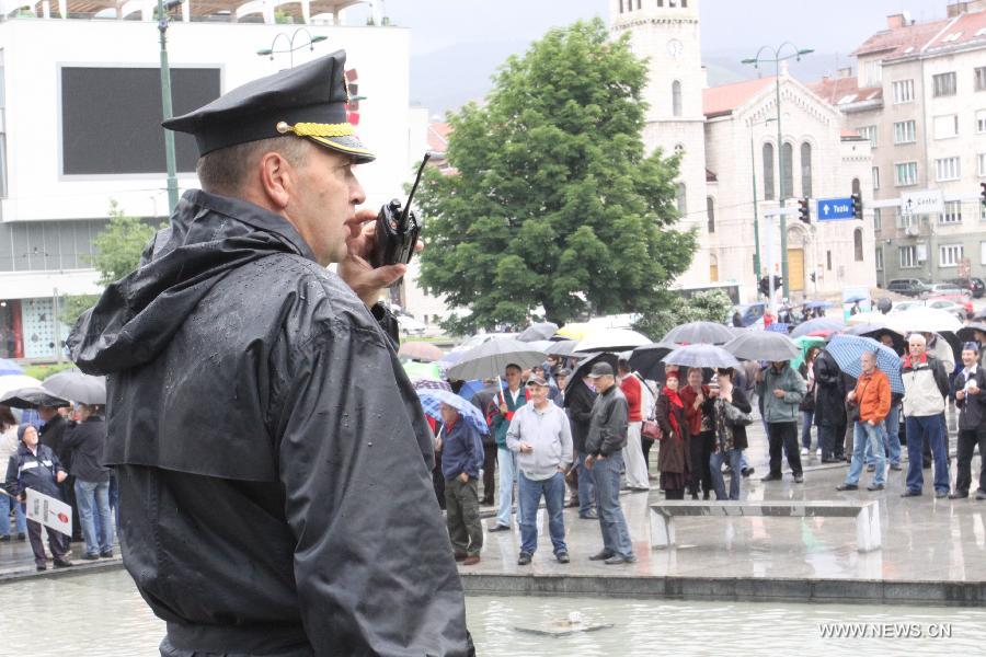 A police officer watches protestors during a protest demanding better income and treatment near Parliament of Bosnia and Herzegovina (BiH), in Sarajevo, BiH on May 30, 2013. Over 1,000 people participated in the protest. (Xinhua/Haris Memija)