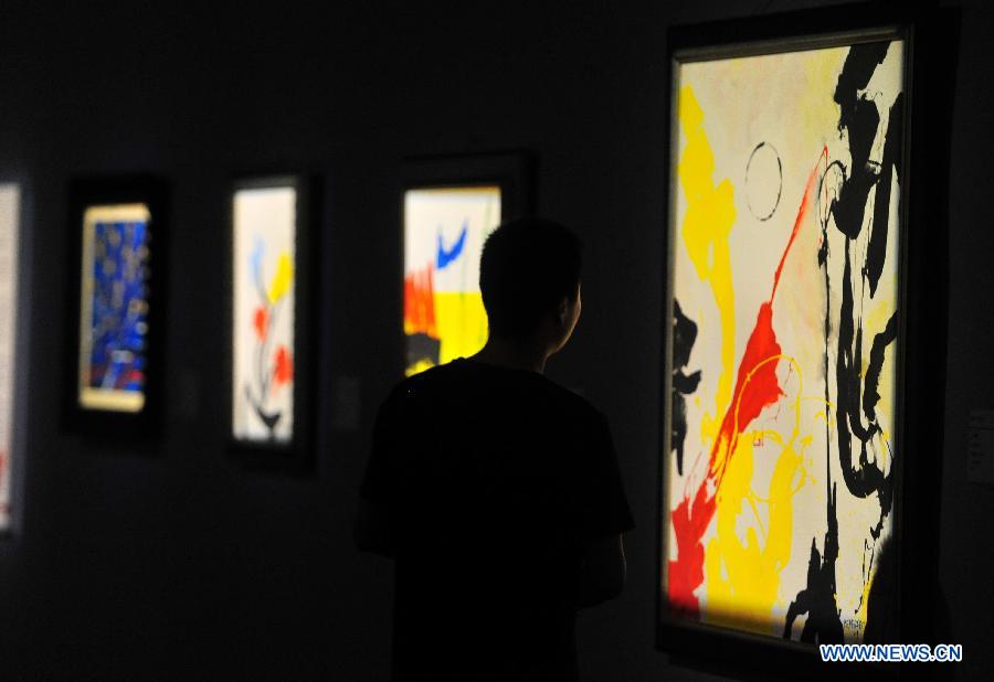 A visitor looks at a painting of Antonio Meneghetti, the father of onto-psychology, at an exhibition in Wuhan, capital of central China's Hubei Province, May 30, 2013. An exhibition of Meneghetti's paintings kicked off at the provincial museum here on Thursday. Meneghetti, who was supposed to attend his exhibition's opening ceremony, has passed away on May 20 at the age of 77 in Italy. (Xinhua/Xiao Yijiu)