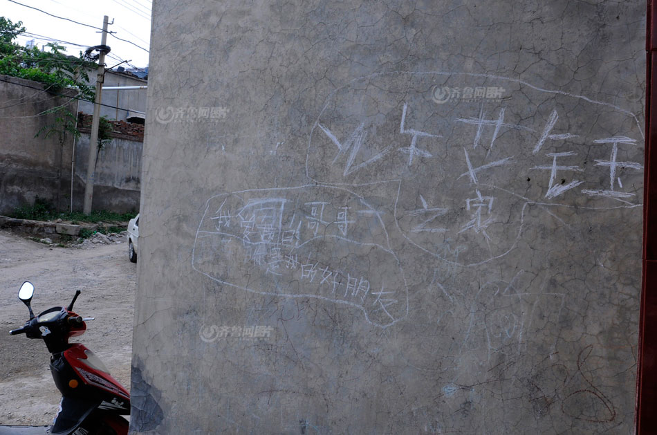 Xu's graffiti on outside wall of home read "Mama, I love you", "brother, I love you", and "bother is my best friend". (www.iqilu.com/ Yu Peng)