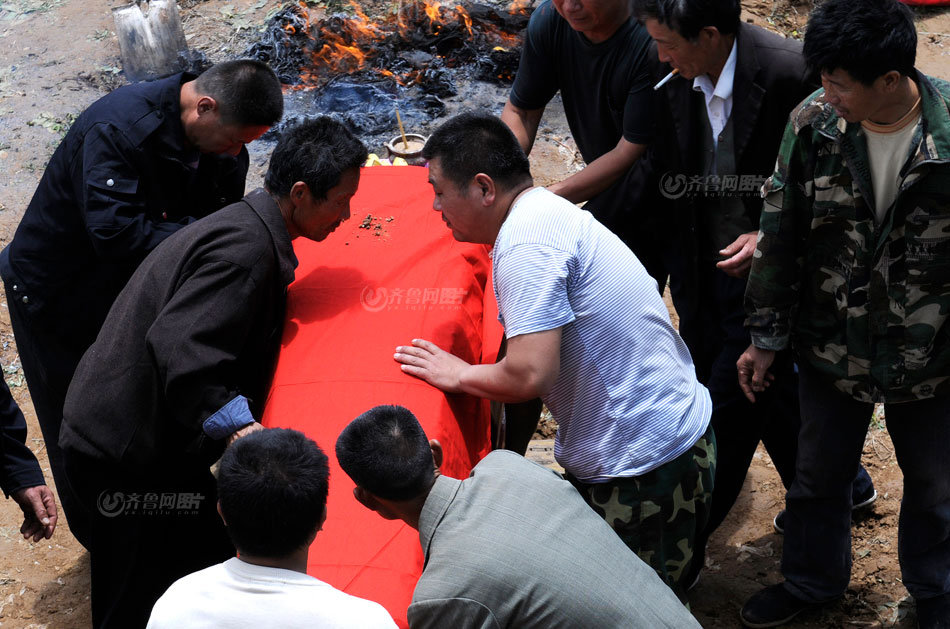 Xu's family members pay last respect at her funeral. The villager carried the coffin to cremation. (www.iqilu.com/ Yu Peng)
